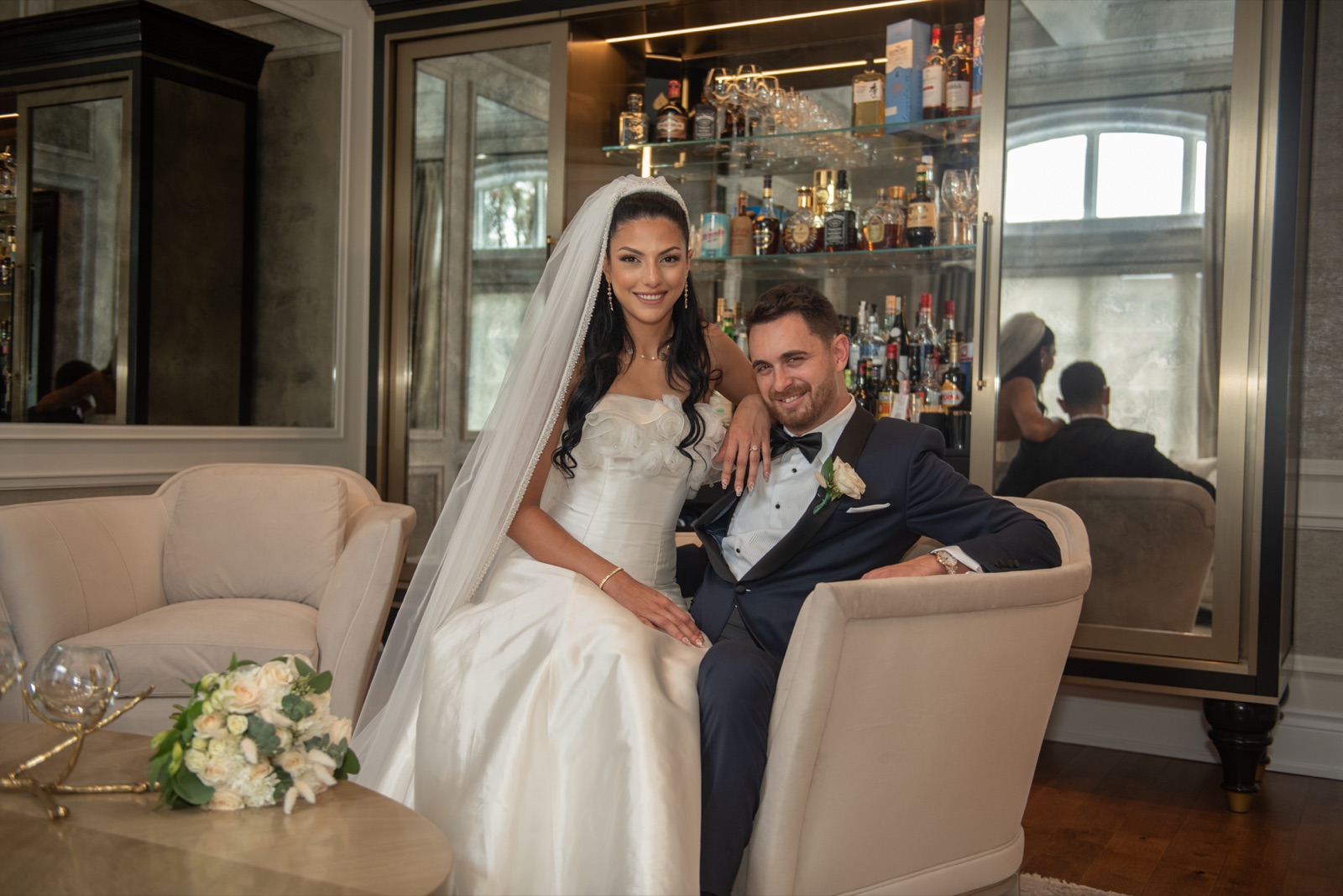 Sally and Nick seated together in their wedding attire